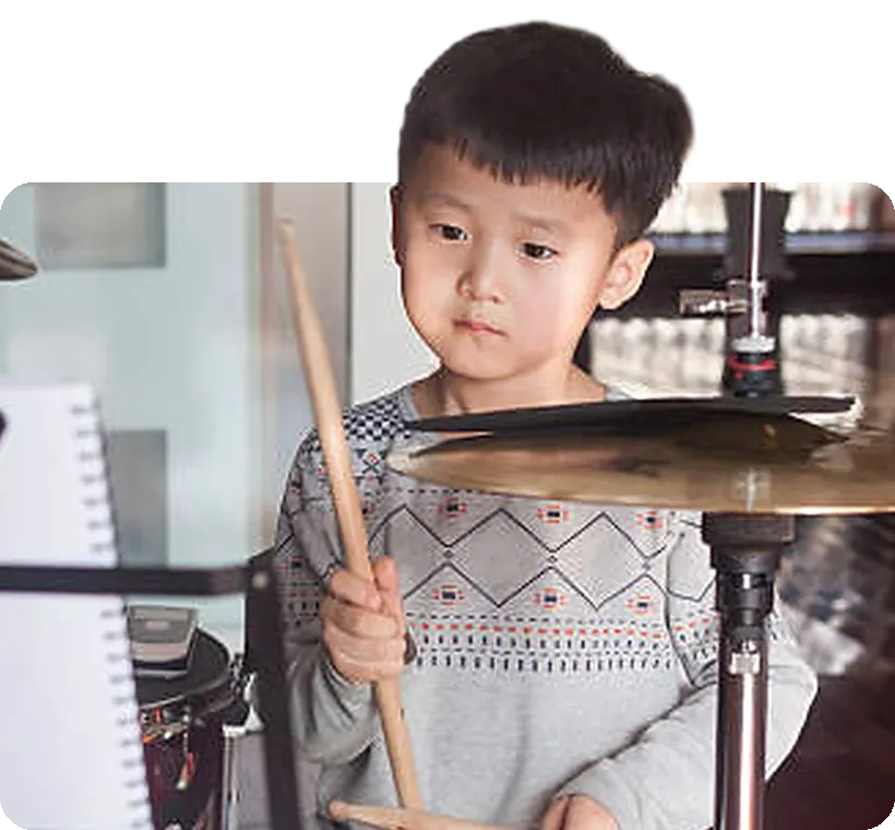 A young drummer at his kit, sticks ready.