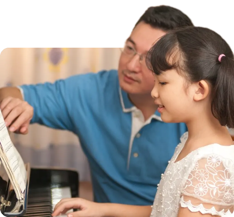 A girl at the piano with her teacher.